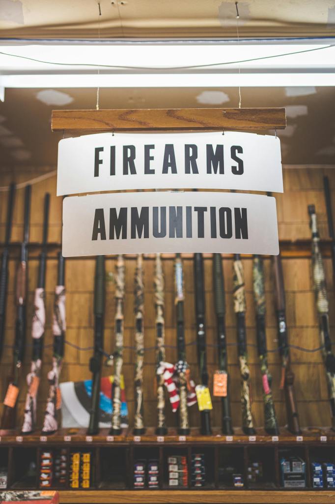 pexels-photo-9747129-9747129 Signage in a firearms and ammunition store showcasing rifles and related products.